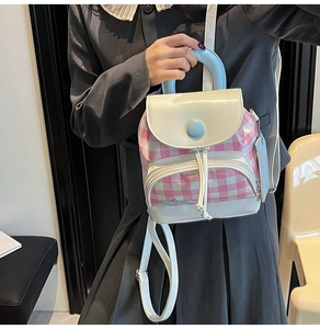Close-up of pink and white checkered mini backpack with white flap and light blue handle