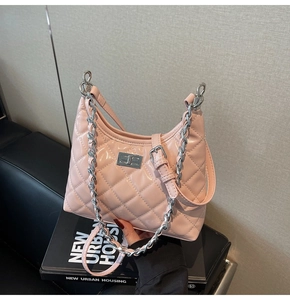 Detail of light pink quilted leather bag with silver twist lock and chain strap