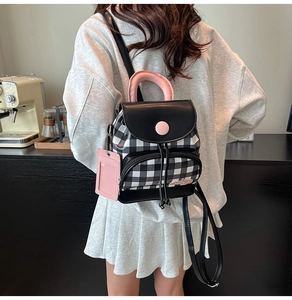 Mini backpack featuring checkered pattern and pink accents shown in a lifestyle cafe setting