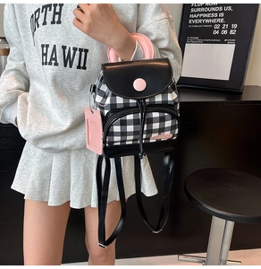 Detailed view of mini checkered backpack with pink handle and drawstring closure
