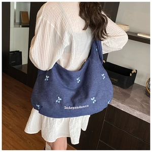 Vue arrière d'un grand sac hobo en jean bleu marine avec broderies et texte Independence