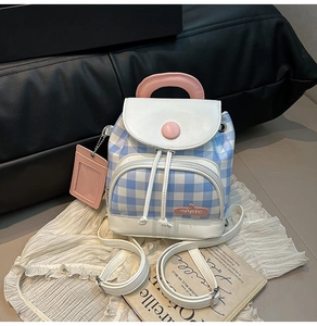 Detail of blue checkerboard mini backpack with pink handle and detachable card holder