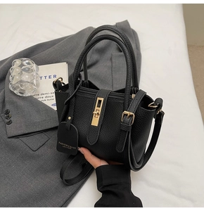 Detailed close-up of a black lychee texture bucket bag with elegant gold hardware buckles