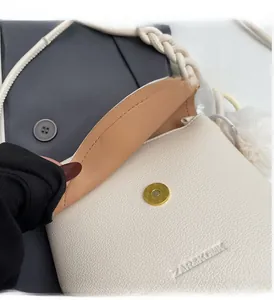 Close-up of ivory lychee leather bag with gold magnetic buckle and refined brand logo