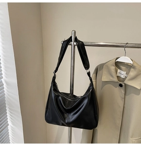 Detail view of the black soft PU leather hobo bag with a silver zipper and wide strap