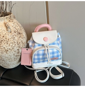 Detailed view of mini blue plaid backpack with pink accents and matching card holder