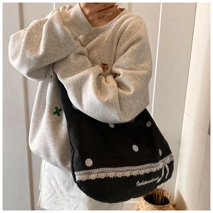 Vue détaillée du sac cabas noir à pois avec bordure en dentelle blanche et noeud