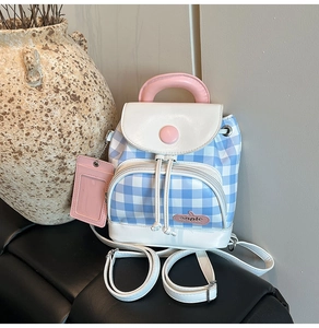 Detail of mini blue checkered backpack with pink handle and matching card holder tag