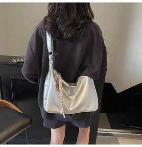 Silver metallic oversized dumpling crossbody bag styled on a casual waffle texture hoodie