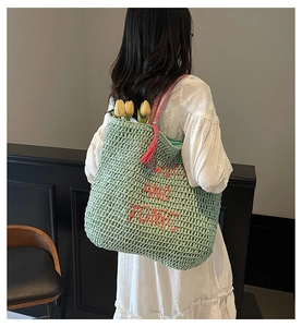 Mint green straw woven tote with Swim and Tonic embroidery and decorative red tassels