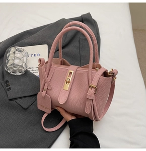 Detail of pink lychee texture leather bucket bag with gold hardware and logo tag