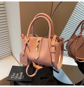 Detailed macro view of pink lychee pattern texture and gold metal turn-lock on bucket bag