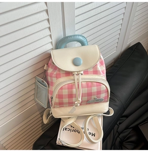 Detail of pink plaid mini backpack featuring cream leather trim and matching card holder
