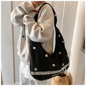 Détail du sac en toile avec pois brodés, bordure en dentelle et détails de nœuds