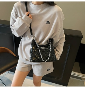 Détail du sac en cuir verni matelassé noir avec chaîne argentée et fermoir pivotant chic