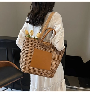 Große geflochtene Stroh-Tote-Bag mit braunen Lederriemen und gelben Tulpen im Detail