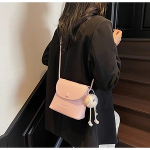 Pink lychee grain leather crossbody bag with a cute white fluffy ball charm and round buckle