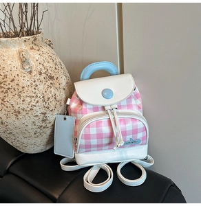 Detail showing the pink and white plaid pattern and drawstring closure of the mini backpack