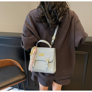 Détail d'un sac à dos en cuir synthétique bleu clair avec motifs gaufrés et plaque logo