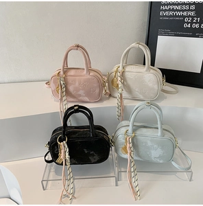 Detail der Mini-Handtasche mit Schmetterlingsprägung und gewebter Quaste