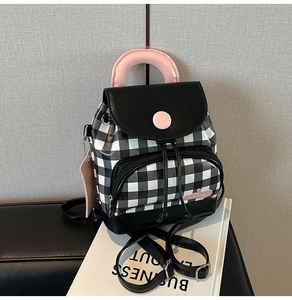 Detail of mini gingham backpack featuring pink handles and secure drawstring closure