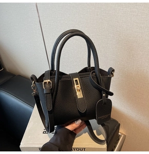 Detail of black lychee grain leather bucket bag with gold buckle and adjustable strap
