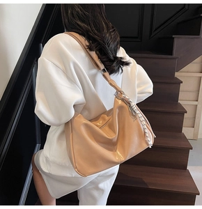 Khaki large capacity hobo bag detail with wide strap and decorative woven pendant