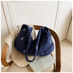 Détail du sac cabas en toile marine avec broderies cerises et coutures de lettres