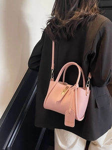 Pink lychee grain leather bucket bag with top handles and a long shoulder strap
