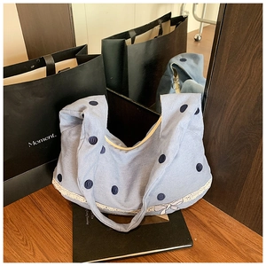 Détail du sac hobo en toile bleu clair à pois avec dentelle blanche et petit nœud