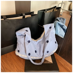 Détail du sac en jean bleu clair avec pois marine et bordure en dentelle blanche