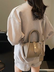 Chic taupe pebble leather bucket bag with gold hardware and a detachable shoulder strap