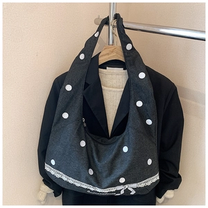 Détail du sac cabas en denim à pois gris avec bordure en dentelle blanche et nœud