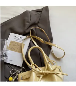 Detailansicht der gelben Beuteltasche mit Schleife und verstellbarem Lederriemen