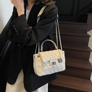 Quilted white leather crossbody bag with silver hardware on model for chic fashion