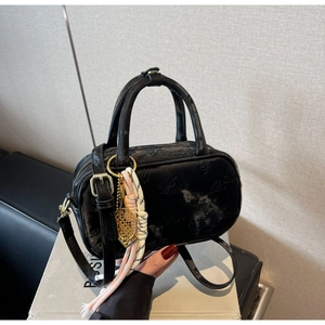 Detailansicht der schwarzen Henkeltasche mit goldener Tennisschläger-Deko und Gurt
