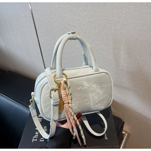 Detail der hellblauen Bowlingtasche mit Prägemuster und rosa Seil-Accessoire am Griff