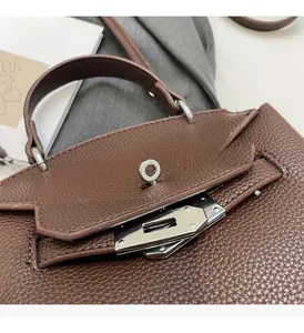 Detail des silbernen Drehverschlusses und der Lederstruktur an brauner Handtasche