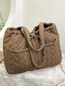 Brown quilted puffer tote bag with leaf pattern stitching and drawstring closure
