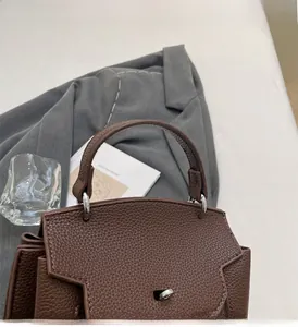 Detail von hochwertigem braunem Leder mit Lychee-Muster und Silberverschluss der Handtasche