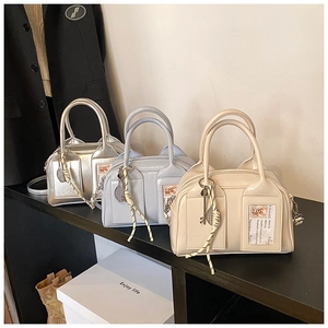 Boston style handbags in silver, blue, and cream with metallic charms and card slots