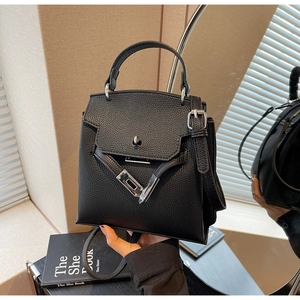 Detail der schwarzen Handtasche aus Narbenleder mit silbernem Drehverschluss aus Metall