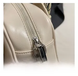 Detailed close-up of premium cream white leather handbag with high-quality silver metal zipper
