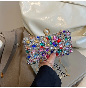 Détail d'une pochette de soirée colorée en strass avec fermoir perle et chaîne dorée