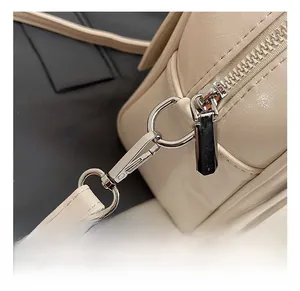Close-up of premium silver metal hook and leather texture on beige crossbody bag