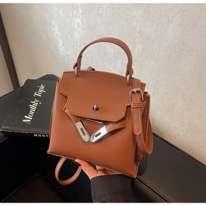 Detailaufnahme der karamellfarbenen Handtasche aus Leder mit silbernem Drehverschluss