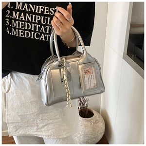 Close-up of metallic silver pillow bag with card slot and decorative key charms