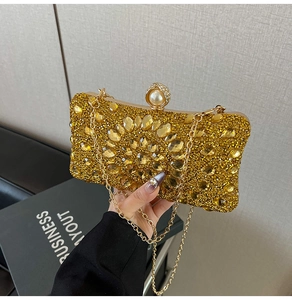 Détail d'une pochette dorée avec strass jaunes radiaux et fermoir en perle élégant