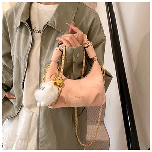 Detail of soft pink crescent bag with pleated handle and golden chain on model
