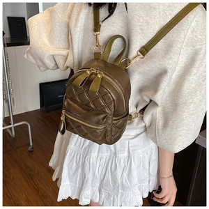 Olivgrüner gesteppter Mini-Rucksack für Damen in der Rückansicht an einem Modell